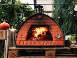 Domowa pizza pieczona w ogrodowym, mobilnym piecu, opalanym drewnem 